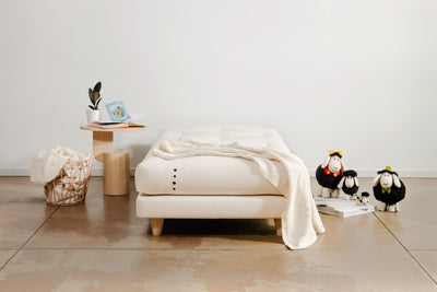 Kids natural mattress on custom base. Decorative wool sheep on the side along with natural decor.
