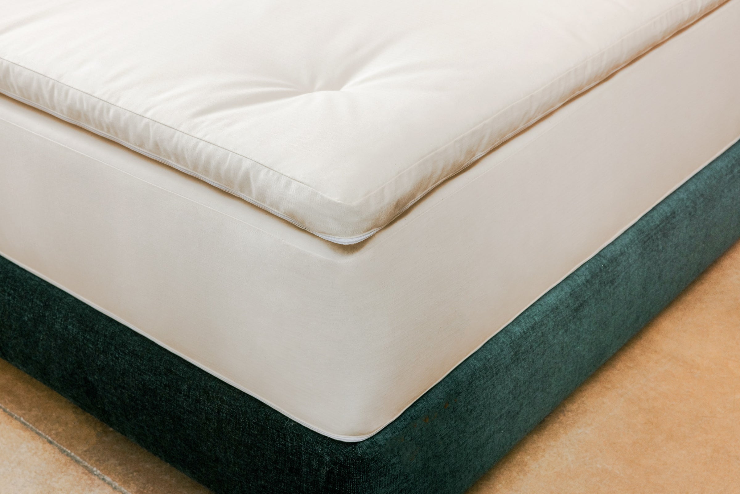 Natural mattress on bed frame with a natural latex and wool topper on top.