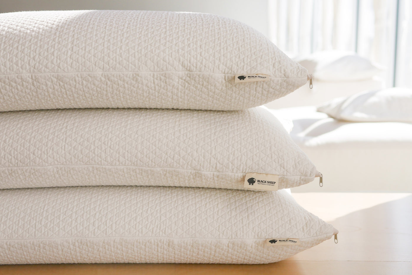 Stack of three 100% natural talalay latex pillows in organic cotton cases