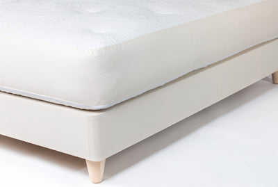 Mattress on the bed base with natural round wood legs