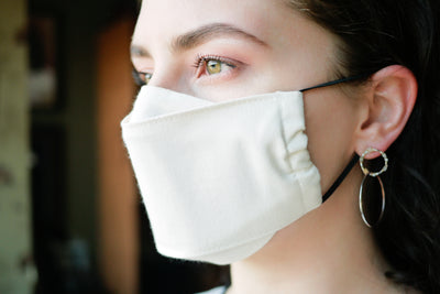 Woman wearing contoured organic cotton face mask with adjustable elastics